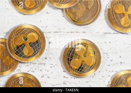 Flat lay photo - golden ripple cryptocurrency coins on white stone board. Stock Photo