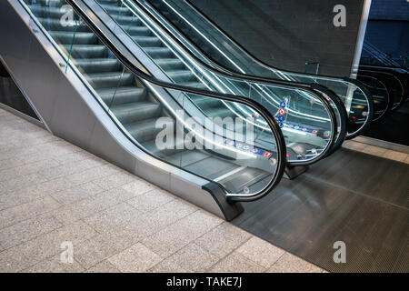 Lower floor near illuminated empty escalators in modern building Stock Photo