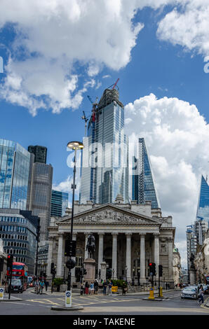 The London Skyline featuring old architecture of The Royal Exchange Building and modern glass skyscrapers beyond which reflect the blue sky. Stock Photo