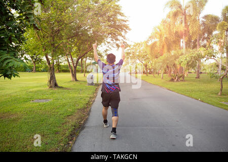 Excited man raising arms celebrating sucess in the middle of the street ...