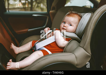 Baby sitting in safety rear-facing car seat family lifestyle vacation road trip child security transportation Stock Photo