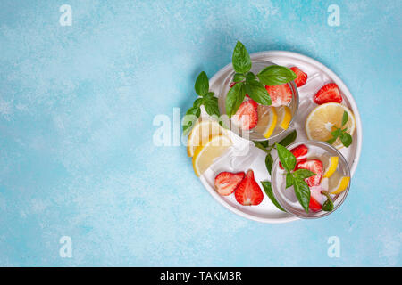 strawberry basil lemonade in a glass, fresh strawberries, basil on a blue background Stock Photo