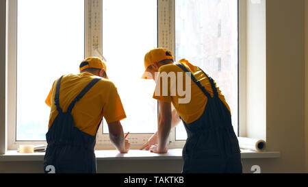 Construction co-workers discussing work plan. Project discussion at construction site. Stock Photo