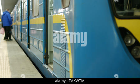 Close up view of train at indoor subway station. People at a subway station platform entering a train. Stock Photo