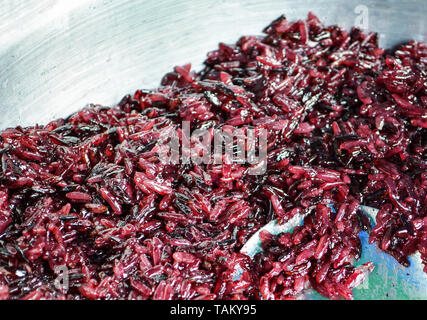 Organic cooked rice purple purple rice berry steamed  - black jasmine rice in pot Stock Photo