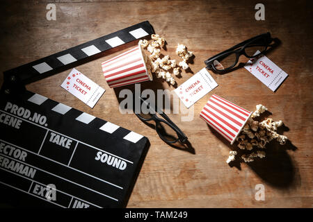 Composition with cinema clapperboard and popcorn on wooden background Stock Photo
