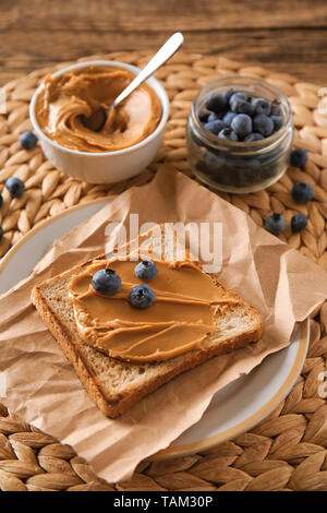 Toasted bread with tasty peanut butter and berries on table Stock Photo
