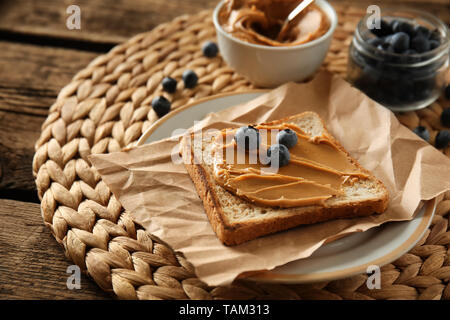 Toasted bread with tasty peanut butter and berries on table Stock Photo