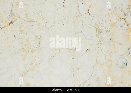 beige cracked background. Cracks on the white old dirty wall. Stock Photo