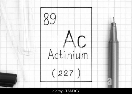The Periodic table of elements. Handwriting chemical element Actinium Ac with black pen, test tube and pipette. Close-up. Stock Photo