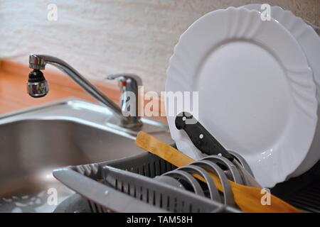 Dishes in drip tray. Clean washed dishes in the kitchen. Stock Photo