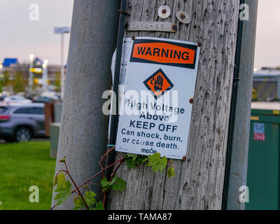 High voltage warning sign on utility pole. Stock Photo