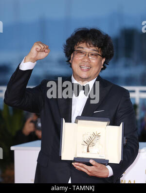 Cannes, France. 25th May, 2019. South Korean director Bong Joon-Ho, winner of the Palme d'Or award for the film 'Parasite' poses during a photocall at the 72nd Cannes Film Festival in Cannes, France, on May 25, 2019. The curtain of the 72nd edition of the Cannes Film Festival fell on Saturday evening, with South Korean movie 'Parasite' winning this year's most prestigious award, the Palme d'Or. Credit: Gao Jing/Xinhua/Alamy Live News Stock Photo