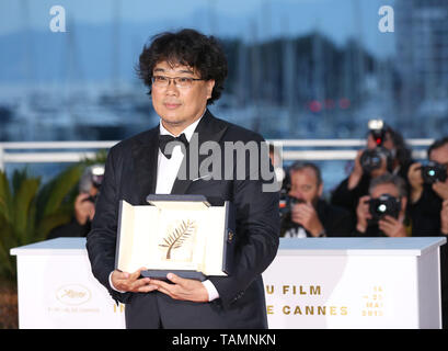 Cannes, France. 25th May, 2019. South Korean director Bong Joon-Ho, winner of the Palme d'Or award for the film 'Parasite' poses during a photocall at the 72nd Cannes Film Festival in Cannes, France, on May 25, 2019. The curtain of the 72nd edition of the Cannes Film Festival fell on Saturday evening, with South Korean movie 'Parasite' winning this year's most prestigious award, the Palme d'Or. Credit: Gao Jing/Xinhua/Alamy Live News Stock Photo
