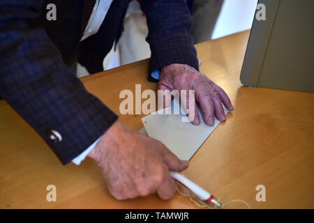 Wildenberg, Germany. 26th May, 2019. A man prepares to vote at a polling station in Wildenberg, Germany, on May 26, 2019. Voters in Germany cast their ballots on Sunday in elections to the European Parliament (EP). Credit: Lu Yang/Xinhua/Alamy Live News Stock Photo