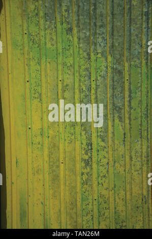 Metal plate with cracks and peeling paint, forming a singular background. Stock Photo