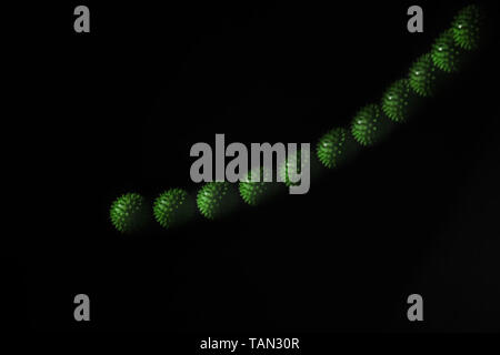 Stroboscopic photo of green moving ball on dark background Stock Photo