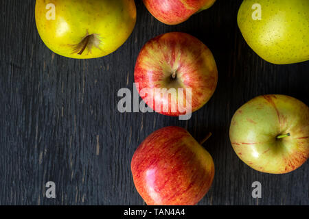 Red and green apples on a dark wood background - top view Stock Photo