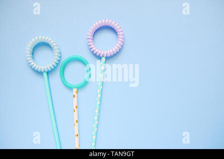 flat lay flowers of spiral hair bands and tubes on a blue background copy space, abstract background Stock Photo
