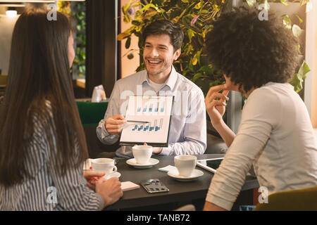 Managers analyzing chart at a business lunch Stock Photo