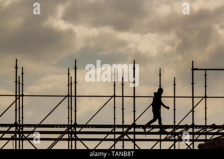 Construction workers silhouette working on iron platform sky background Stock Photo