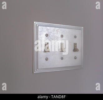 Close up of the wall mounted electrical light switch inside a house. The shiny vertical flip toggle light switches are in off mode. Stock Photo