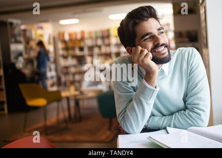 Smiling male student working and learning in a library Stock Photo