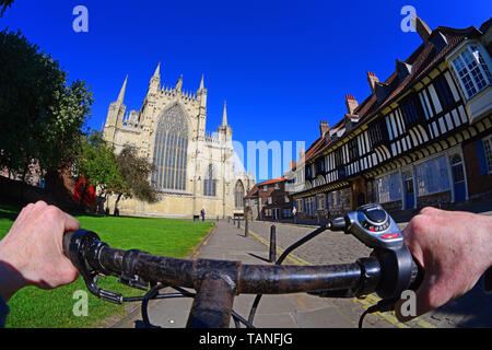 cyclist riding past st williams college and the majestic east transcept of york minster yorkshire united kingdom Stock Photo