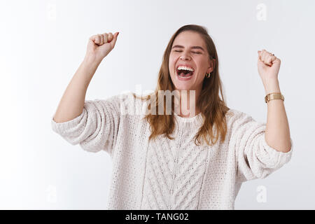 Sweet taste victory. Portrait very happy attractive celebrating young woman jumping happiness win raising clenching fists success accomplishment Stock Photo