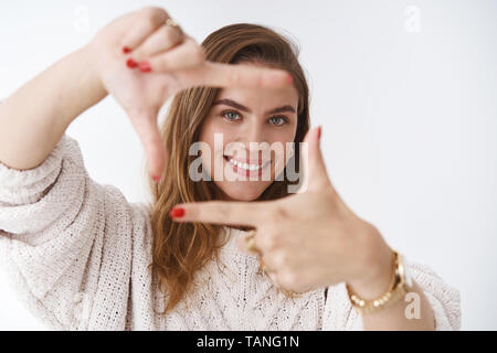 Creative good-looking woman using imagination picturing new appartment design how capture you making finger frame looking through curious delighted Stock Photo