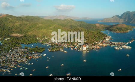 Aerial view Coron city with slums and poor district. sea port, pier, cityscape Coron town with boats on Busuanga island, Philippines, Palawan. Seascape with mountains. Stock Photo