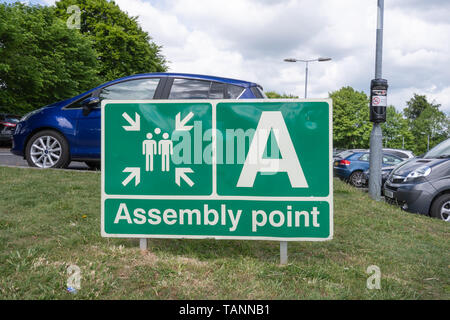 Fire assembly point sign in a car park, where people assemble after evacuating a building in the event of a fire or other emergency. Health and safety Stock Photo