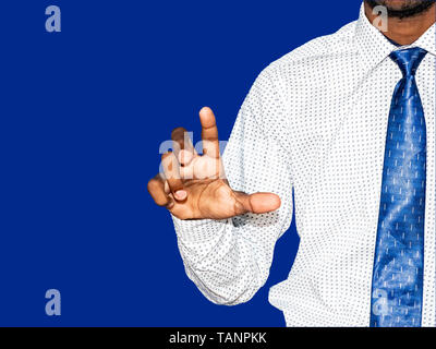 Young indian business man clicking pressing button on virtual screen on blue colorful background. For customer support of technology artificial intell Stock Photo