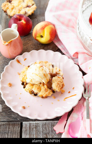 Peach crumble a la mode, with a scoop of vanilla ice cream Stock Photo