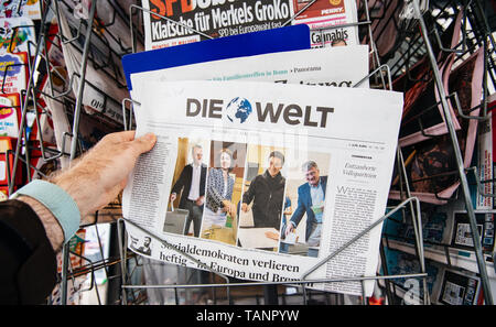 Strasbourg, France - May 27, 2019: Man holding buying Die Welt newspaper front page on street press kiosk newsstand with the results of 2019 European Parliament election  Stock Photo