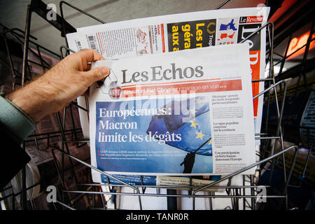 Strasbourg, France - May 27, 2019: Man holding buying Les Echos newspaper front page on street press kiosk newsstand with the results of 2019 European Parliament election  Stock Photo