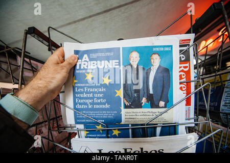 Strasbourg, France - May 27, 2019: Man holding buying La Tribune newspaper front page on street press kiosk newsstand with the results of 2019 European Parliament election  Stock Photo