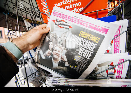 Strasbourg, France - May 27, 2019: Man holding buying Liberation newspaper front page on street press kiosk newsstand with the results of 2019 European Parliament election  Stock Photo