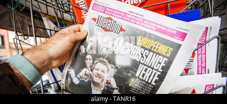 Strasbourg, France - May 27, 2019: Wide image Man holding buying Liberation newspaper front page on street press kiosk newsstand with the results of 2019 European Parliament election  Stock Photo