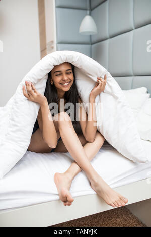 Young woman resting under a duvet in her bed Stock Photo