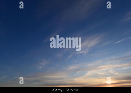 Brightly lit in sunset  blue sky in white cirrus clouds Stock Photo