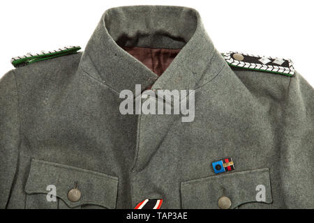 A field tunic M 38 for an SD-Hauptscharführer depot piece from the duty station in Prague Cut in the style of the black tunic, made of field-grey woollen cloth with metal buttons, brown lining with bandage pack pocket and depot stamp 'G.St. Prag'. Black collar patches without piping (from 1942 onwards), slip-on shoulder-boards with police pattern but with black interweaves and middle section. Sleeve eagle and SD sleeve diamond in light-coloured RZM embroidery on black ground. War Merit Cross ribbon, field orders clasp with SS Long Service Award and pinned-on SA Sports Badge, Editorial-Use-Only Stock Photo