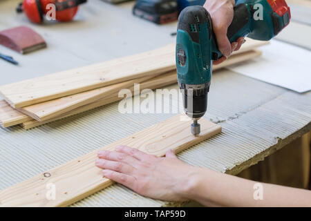 Detail of drill making hole into wooden plank Stock Photo