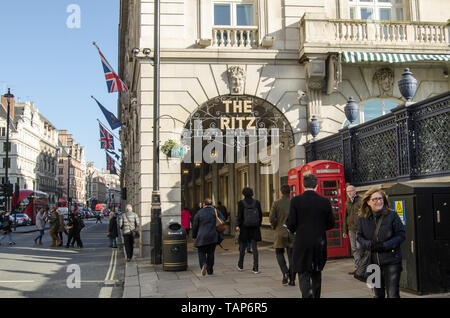 LONDON, UK - JANUARY 28, 2016:  Pedestrians and traffic at the Ritz Hotel arcade in Piccadilly, London on a sunny winter afternoon in central London. Stock Photo