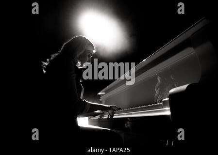 Close up view of a girl plays piano in the concert hall at scene Stock Photo