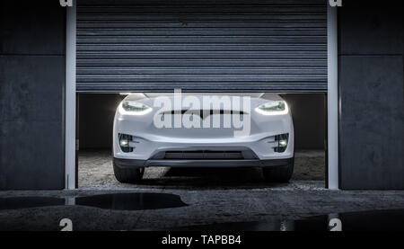 Modern electric machine with the headlights on and located in a garage with a half-lift damper. 3d render Stock Photo