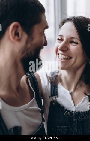 happy couple smile and laugh to each other near the window Stock Photo