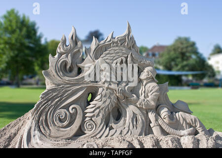 sand sculpture of a dragon and fire fighter Stock Photo