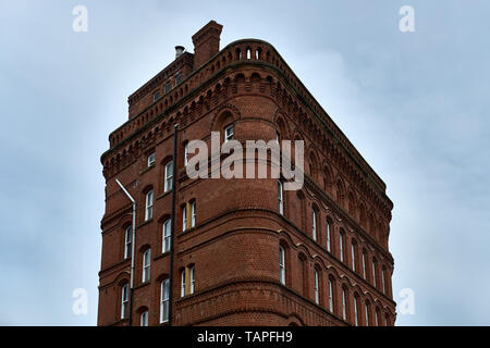 A twentieth century red brick building stands isolated against a pale sky in Leeds, Yorkshire. UK Stock Photo