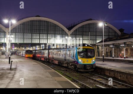 A First Transpennine Express class 185 at Hull Paragon station waiting to depart with a early morning train with Northern Rail pacer trains alongside Stock Photo